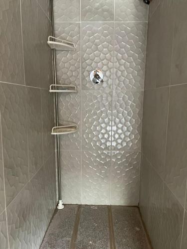a shower stall with a glass door with shelves at Killa Glamping in Sangolquí