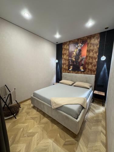 a bedroom with a bed and a painting on the wall at Байсанат 2 in Karagandy
