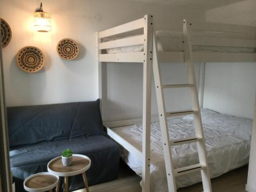 a bunk bed and a ladder in a room with a couch at Studio proche océan dans résidence 3 étoiles avec piscine et parking privé in Mimizan-Plage
