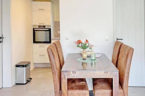a dining room table with chairs and a vase of flowers at Wachtelkönig in Lübbenau