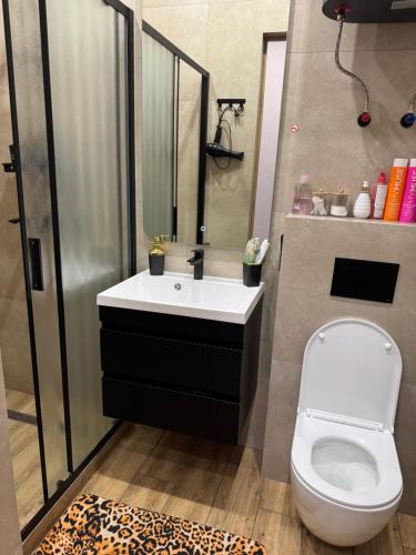 a bathroom with a toilet and a sink with a mirror at Байсанат 2 in Karagandy