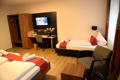 a hotel room with two beds and a desk at Brauerei Walter in Waldshut-Tiengen