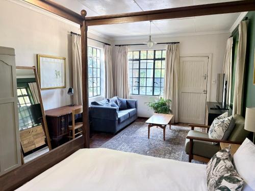a living room with a bed and a couch at Oatlands Cottages in Grahamstown