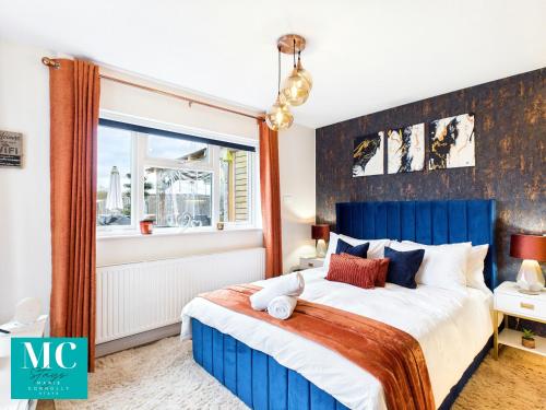 a bedroom with a blue and white bed and a window at The Cosy Retreat in Droitwich