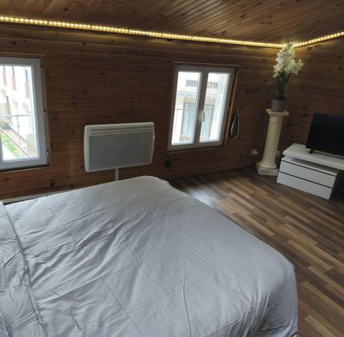 Le chalet في La Celle-sous-Gouzon: غرفة نوم بها سرير أبيض ونافذتان