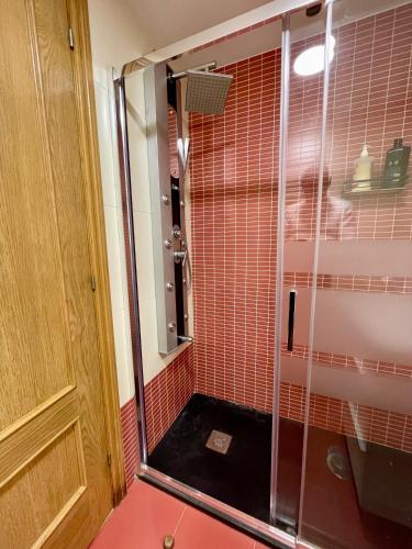 a bathroom with a shower with red tile at Can Rios-Felechosa - Aller in Felechosa