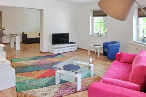 a living room with a pink couch and a tv at Lilie in Lübbenau