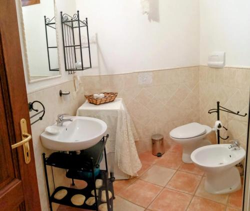 a bathroom with a sink and a toilet at Grazioso appartamento con tutti confort in Lu Lioni