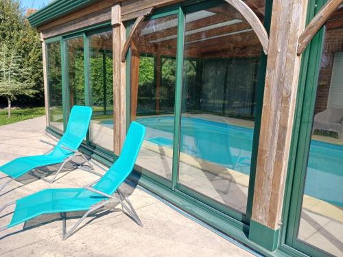 deux chaises assises sur une terrasse à côté d'une piscine dans l'établissement Gale'o Loft, à Cayeux-sur-Mer
