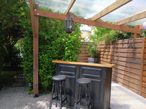 - un bar extérieur avec tabourets sous une pergola en bois dans l'établissement Gale'o Loft, à Cayeux-sur-Mer
