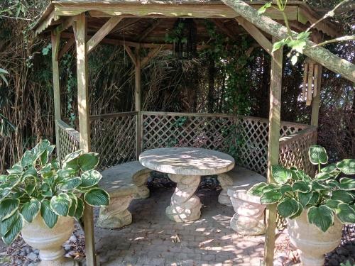 un gazebo en bois avec un banc et une table dans l'établissement Gale'o Loft, à Cayeux-sur-Mer