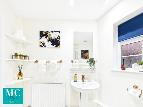 a white bathroom with a sink and a toilet at The Cosy Retreat in Droitwich