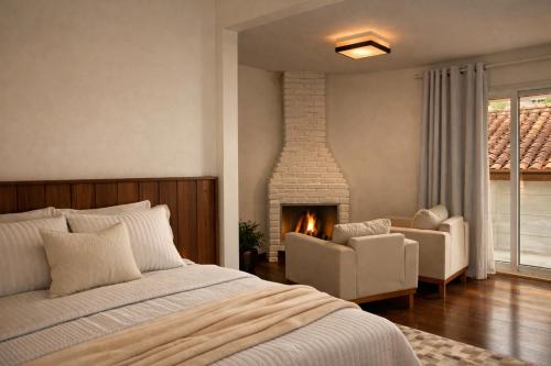 a bedroom with a bed and a fireplace at Pousada Águas do Alto in São Francisco Xavier