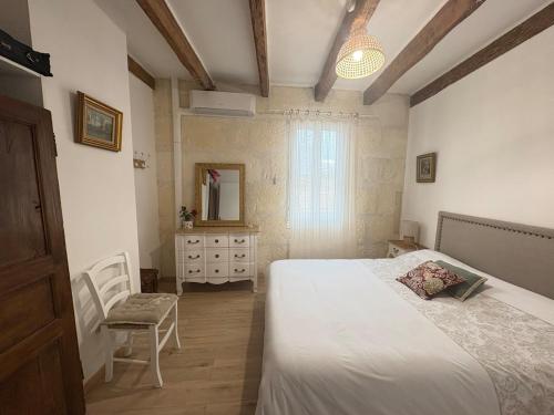 a bedroom with a bed and a dresser and a mirror at Chez Fabienne Maison Fontvieille in Fontvieille