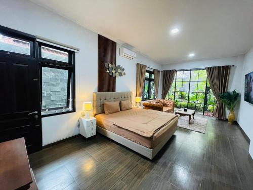 a bedroom with a bed in a room with windows at Ornella Villa in Yogyakarta