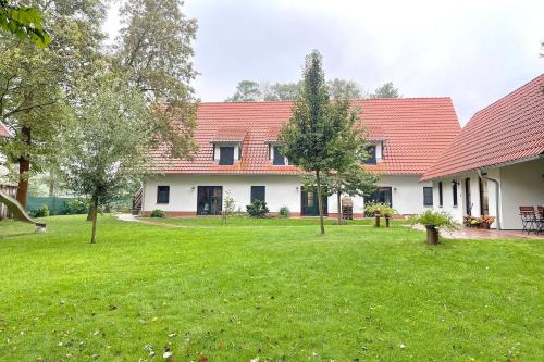 a house with a red roof and a yard at Spreeblick Baum 5 in Burg