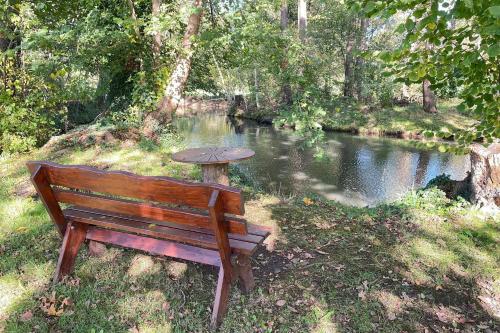 a bench sitting next to a river with a table at Spreeblick Baum 5 in Burg