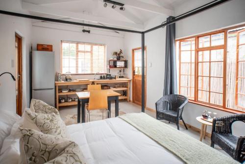 a bedroom with a bed and a table and a kitchen at Parmant in Robertson