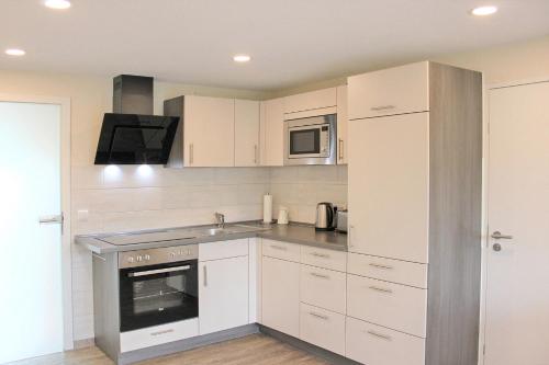 a kitchen with white cabinets and a stove at Quartier Spreestraße - App 4 in Burg