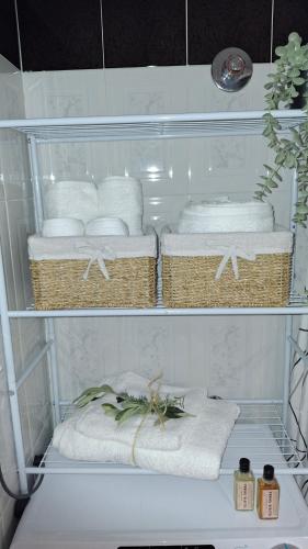 a rack of towels and baskets on a shelf at SweetHome Komotini central & comfy apartment with Parking in Komotini