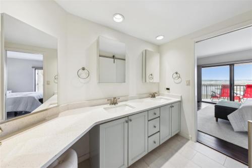 a bathroom with a double sink and a bedroom at 261 Captains Quarters in Hilton Head Island
