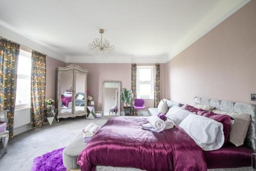 a bedroom with a bed and a purple blanket at Group Accommodation - Rushden A6 Manor House - Private Gated -Sleeps 15 - Secure Parking in Rushden