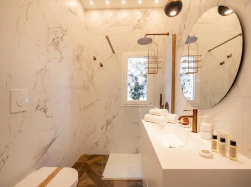 a white bathroom with a sink and a mirror at Sfazion - Central Apartment in Bari
