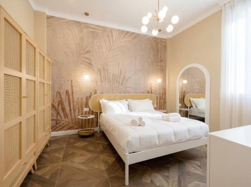 a bedroom with a white bed and a wall mural at Sfazion - Central Apartment in Bari