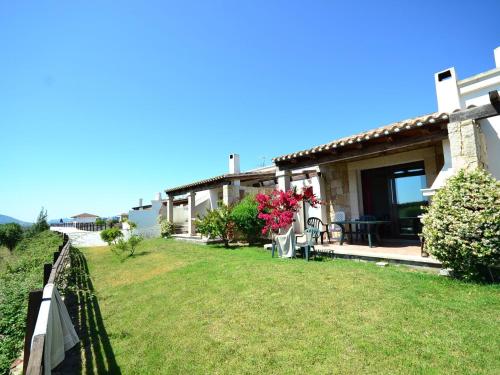 a house with a fence and a yard at Belvilla by OYO Vista Blu Resort Villa Otto Pax in Alghero