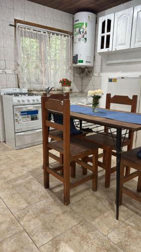 a kitchen with a table and chairs and a stove at Cabaña la Relajación in San Miguel del Monte