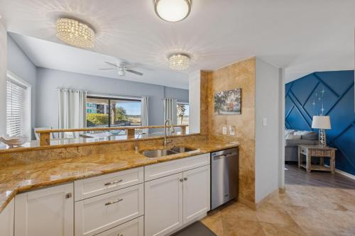 a kitchen with a sink and a living room at 201 Captains Quarters in Hilton Head Island