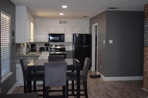 a kitchen with a table and a black refrigerator at The Duplex in Lubbock