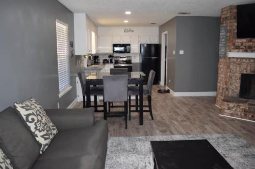a living room with a couch and a table and a kitchen at The Duplex in Lubbock
