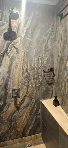 a bathroom with a shower with a stone wall at Hospedaje Solymar Sarie Bay in San Andrés