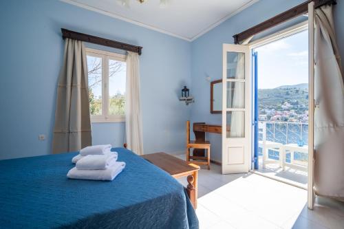 ein Schlafzimmer mit einem blauen Bett, auf dem Handtücher liegen in der Unterkunft Artiki's Studios - Sea & Harbour View Apartments in Symi in Symi