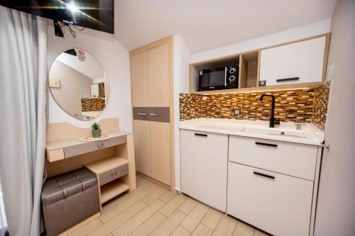 a small bathroom with a sink and a mirror at Amalia Mare in Nea Vrasna