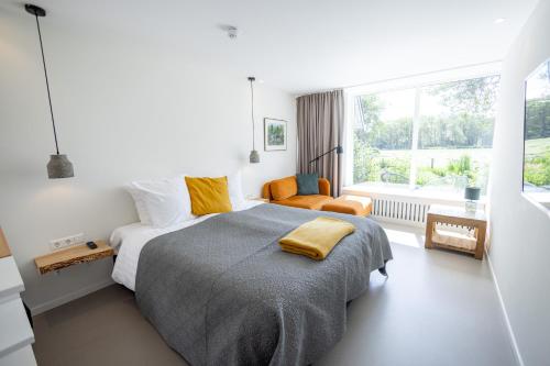 a bedroom with a large bed and a window at Villa de Hazelaar in Schoorl
