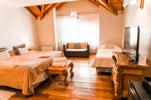 a room with two beds and a couch in it at Nuevo Puerto Malen in Villa Pehuenia