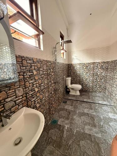 a bathroom with a sink and a toilet at Chara Bloom Hotel in Dickwella