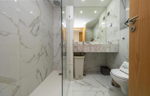 a bathroom with a toilet and a glass shower at B19 - Marina Club Apartment in Lagos