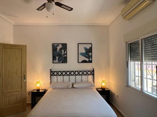 a bedroom with a large bed with two lamps on tables at Casa Noel in Ciudad Quesada