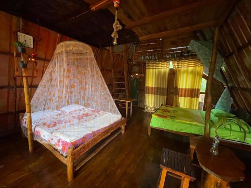 a bedroom with a bed and a hammock in a room at Ella Rock Lodge in Ella