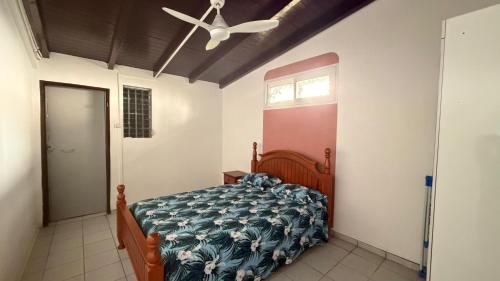 a bedroom with a bed and a ceiling fan at Le lis de Udol in Pointe-à-Pitre