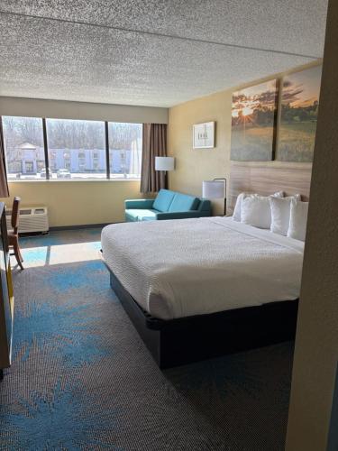 a hotel room with a large bed and a couch at Days Inn by Wyndham Gettysburg in Gettysburg