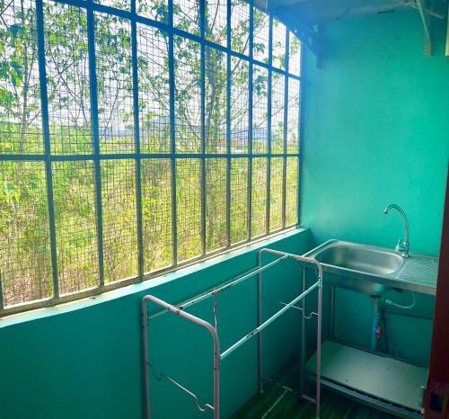 a bathroom with a sink and a large window at สายป่านอาพาร์ทเม้นท์ in Ban Bung Sam Phan Nok