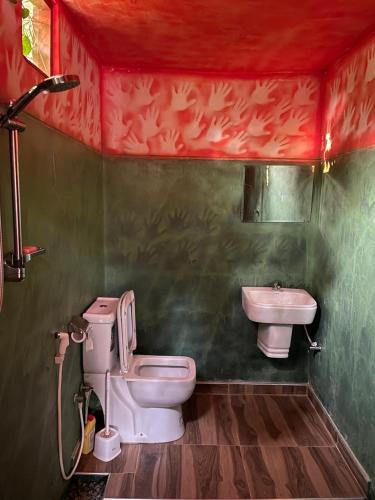 a bathroom with a toilet and a sink at Ella Rock Lodge in Ella