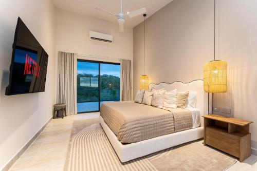 a bedroom with a bed and a large window at 3075 - Paradise Cove 3A Cacalutilla in Tangolunda