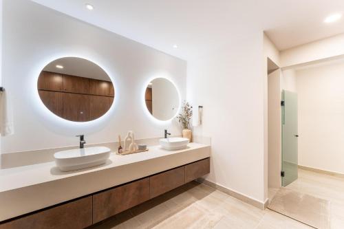 a bathroom with two sinks and two mirrors at 3075 - Paradise Cove 3A Cacalutilla in Tangolunda