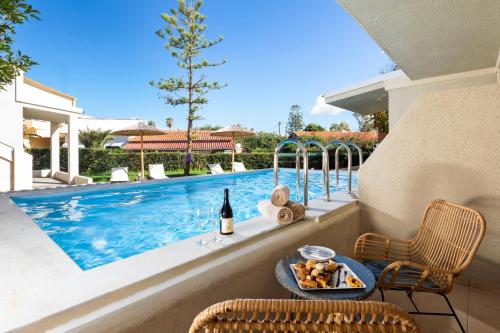 ein Tisch mit einem Tablett mit Essen neben einem Swimmingpool in der Unterkunft Wyndham Corfu Acharavi in (( Litherés ))