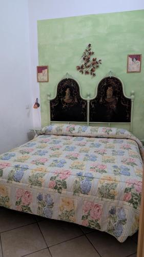 a bed with a quilt on it in a bedroom at Casa Danero "U dabassu" - Centro storico di Carloforte in Carloforte